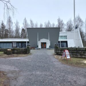 Valkoinen museorakennus pihalta kuvattuna.