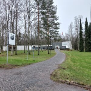 Valkoinen museorakennus näkyy puiston ja puistopolun takana.
